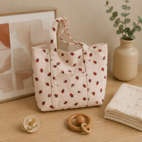 Sac à langer bandoulière, motif ours, en velours, posé dans un intérieur clair aux tons naturels