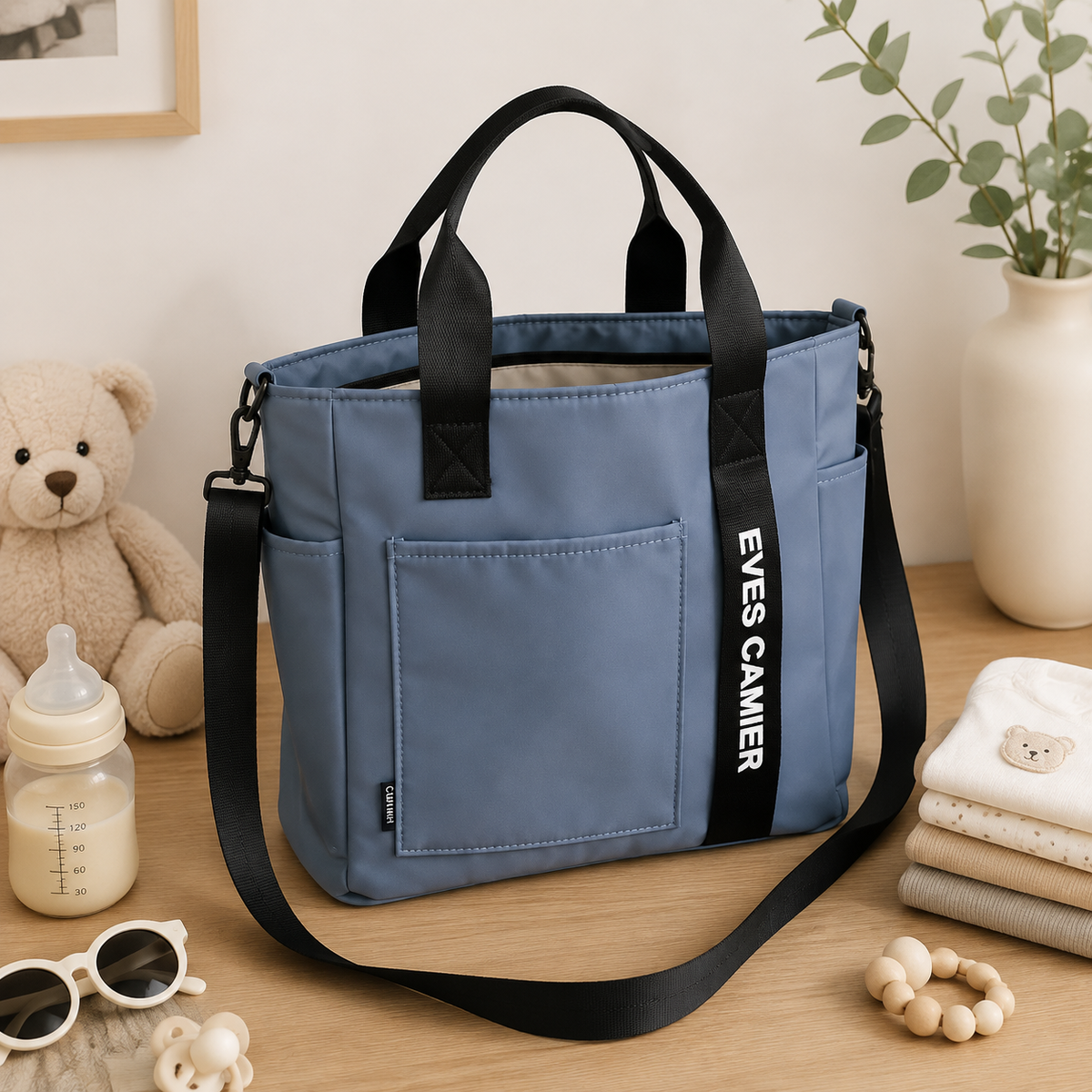 Sac à langer bandoulière, en toile, imperméable, posé dans un intérieur clair aux tons naturels