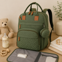 Sac à dos à langer, imperméable, vert, posé dans un intérieur clair aux tons naturels